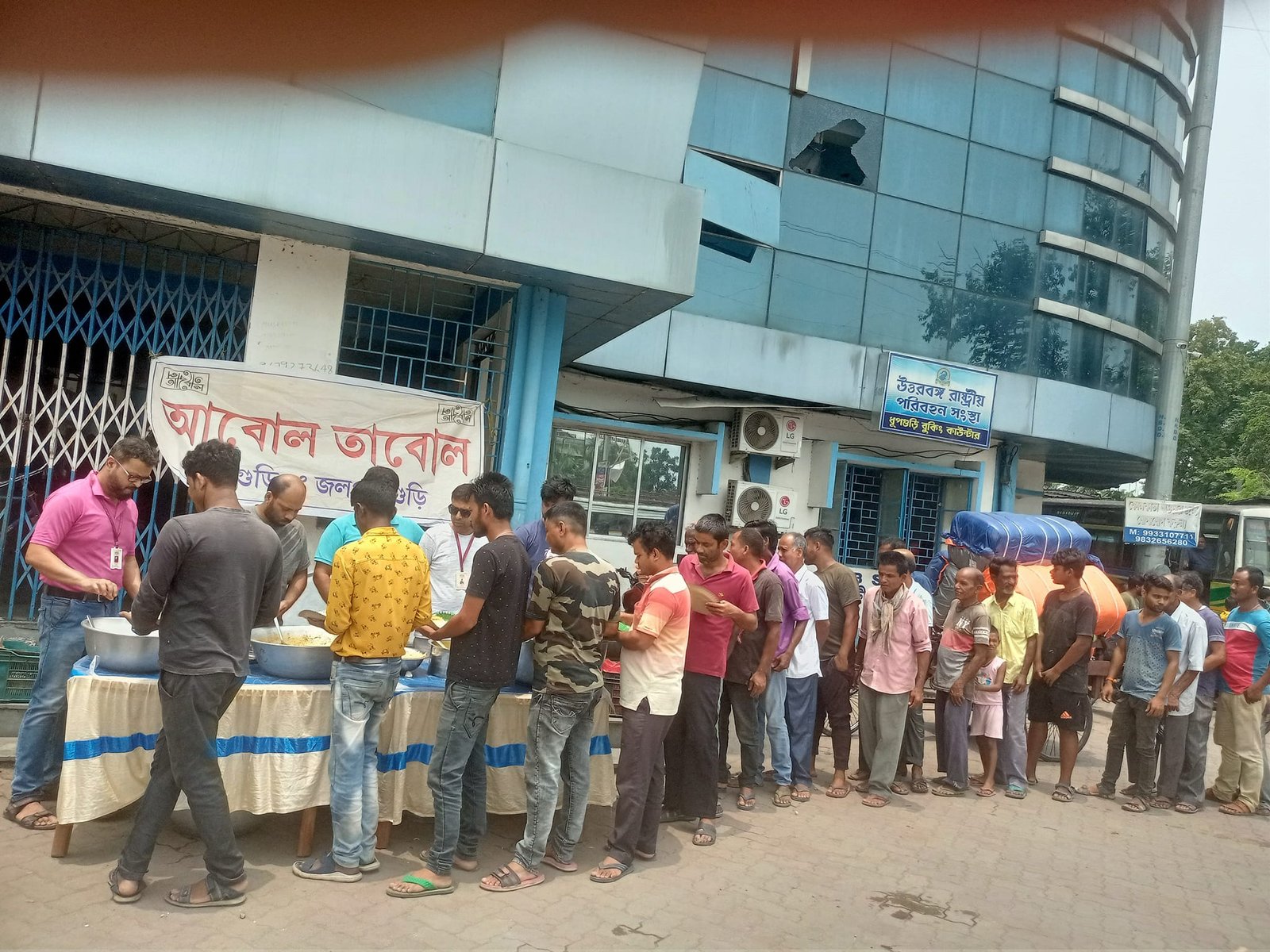 Abol Tabol volunteers serving cooked meals at a street-side counter