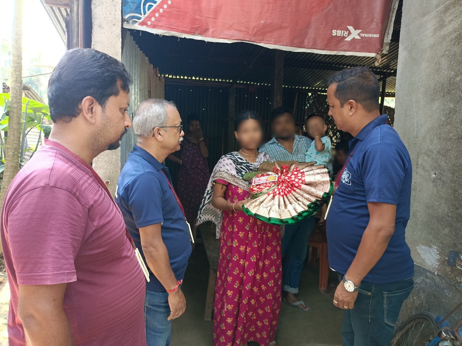 Abol Tabol volunteers handing wedding gifts to a family at their home